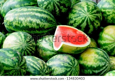 a slice water melon with large quality of the green watermelons