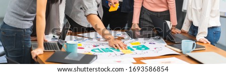 Young Asian creative team work together in business brand design project brainstorm meeting. Modern office, colleague coworker, marketing advertisement research or people teamwork concept. Banner size