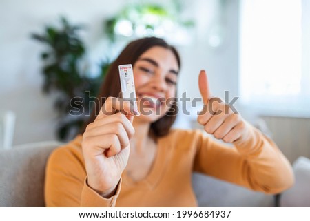 Close-up shot of woman's hand holding a negative test device. Happy young woman showing her negative Coronavirus - Covid-19 rapid test. Focus is on the test.Coronavirus Photo stock © 