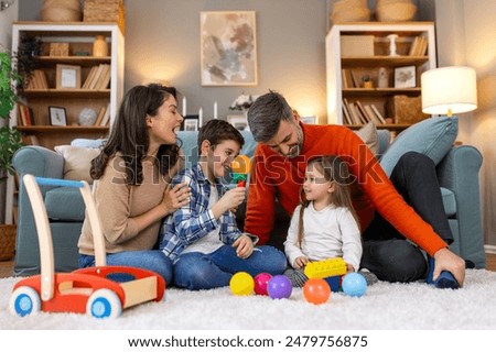 Similar – Image, Stock Photo Children playing with their toys on a wooden floor