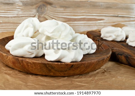 White and pink meringue cookies closeup. Traditional whisk merengues, baked whisking cream or beze on blurred background Imagine de stoc © 