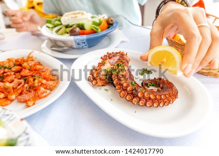 Similar – Image, Stock Photo Woman eating grilled squid skewer in restaurant