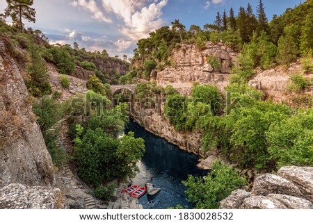 Ancient arch bridge over the Koprucay river gorge in Koprulu national Park in Turkey. Panoramic scenic view of the canyon and blue stormy mountain river Stok fotoğraf © 