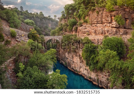 Ancient arch bridge over the Koprucay river gorge in Koprulu national Park in Turkey. Panoramic scenic view of the canyon and blue stormy mountain river Stok fotoğraf © 