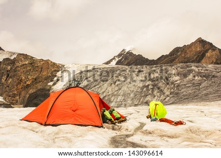 The climber lies in tent of mountain camp with feet outside
