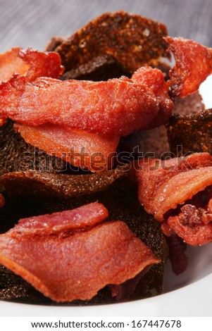 The fried bread, and thin slices of bacon heap. Macro