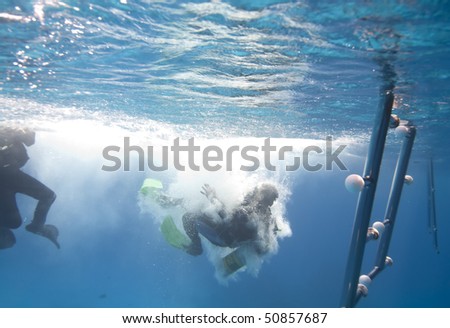 One Scuba diver entering the water from a dive boat. Red Sea, Egypt.