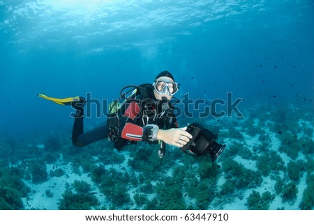 Female scuba diver with underwater video camera