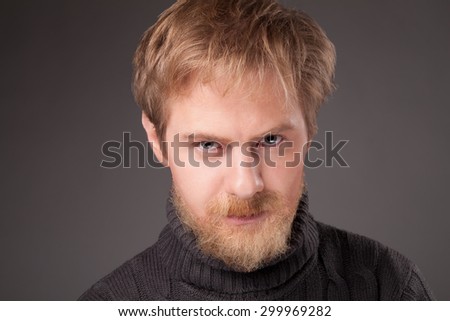 portrait ginger bearded man in jersey against gray background