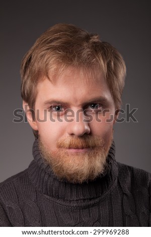 portrait ginger bearded man in jersey against gray background