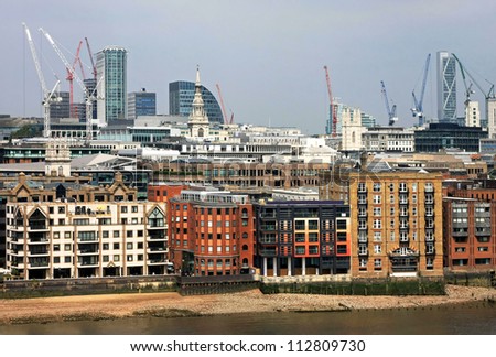 London cityscape from Thames river with building construction sites in background