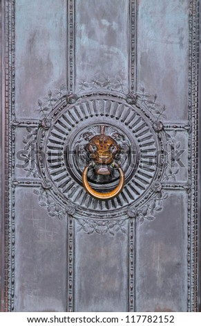 Bronze door knocker detail on ancient door