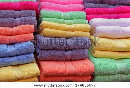 Colorful cotton towels neatly folded on shelf