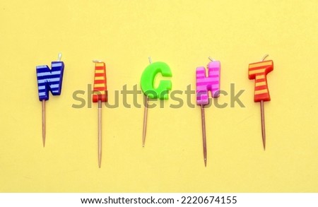 Night word colorful candles text letters isolated on yellow background