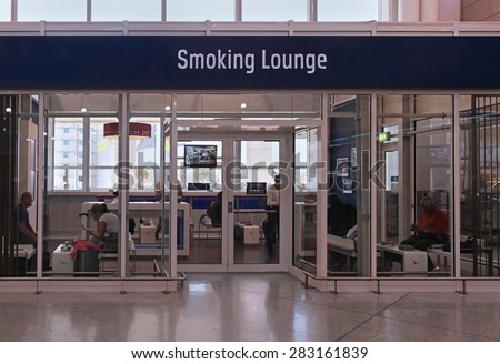 ATHENS, GREECE - May 05: Smoking lounge at Athens airport with passengers inside in Athens, Greece - May 05, 2015; Smoking lounge is the only zone where people can smoke inside airport building.