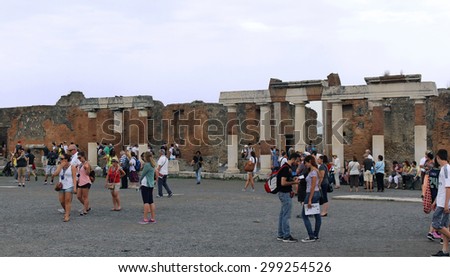 POMPEII, ITALY - June 25, 2014; Famous UNESCO heritage antique ruins in Pompeii, Italy - June 25, 2014; Large square with remains of destroyed ancient city Pompeii with tourists walking around