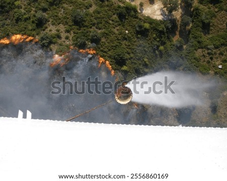 Image, Stock Photo A firefighting helicopter pours water into a forest to put out a forest fire