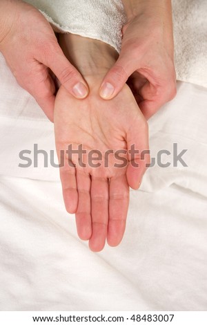 a closeup of a hand of a mature natural woman having a hand reflex zone massage at the thenar