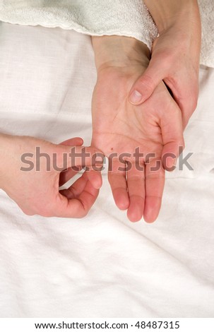 a closeup of a hand of a mature natural woman having a hand reflex zone massage at the thenar and at her little finger
