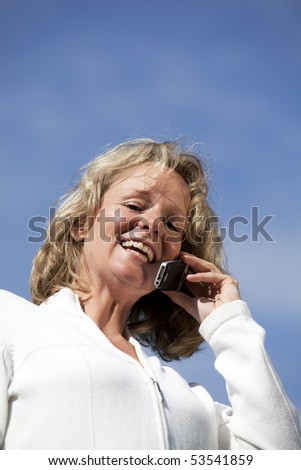 smiling beautiful mature blond woman with a cellphone