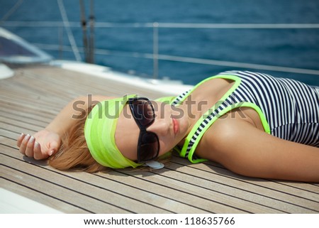 A young beautiful women laying down on a yacht floor