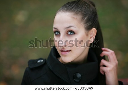 A beautiful brown haired blue eyed model posing outdoor