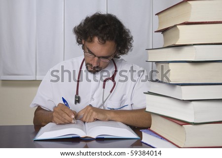 A doctor studying in his office with one pile of books