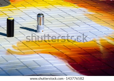 Spray cans on colored pavement