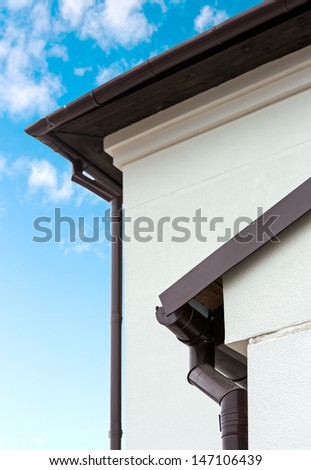 Part of a house with roof, gutter and wall