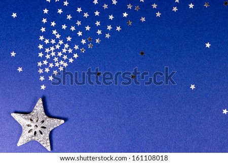 Five pointed silver glitter star on blue