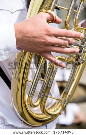 Closeup of copper tuba in hands of musician
