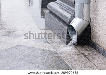 Rain water run out of a downspout during a thunderstorm