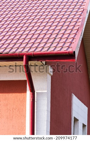 House roof, gutters and downspout on the corner of a house