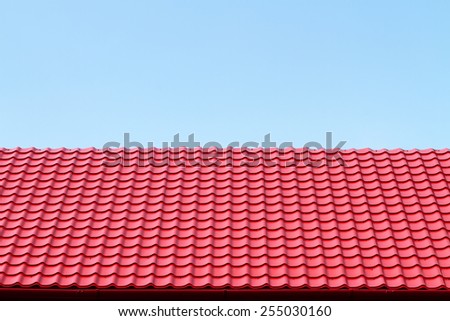 Red roof from a metal tile on a blue sky background