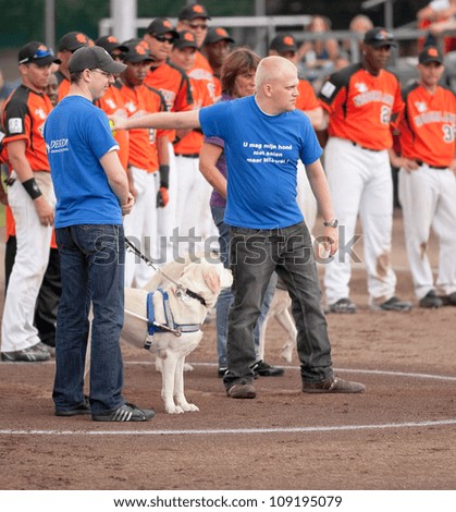 AMSTELVEEN - JULY 28: Visually impaired Mikel Bader throws first pitch at Czech Republic vs The Netherlands game at the softball European championship, on July 28, 2012 in Amstelveen,The Netherlands