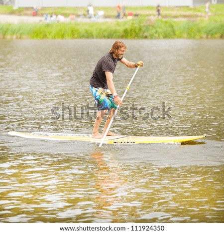 AMSTERDAM - SEP 2: Unidentified city native participates in stand up paddle surfing (SUP) clinic, held during Dutch Paddling Championships, on September 2, 2012, Bosbaan, Amsterdam, The Netherlands