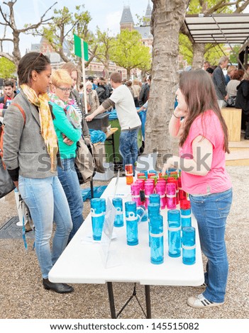 AMSTERDAM - JUNE 29: Visitors check water bottle stand that raises money for a fairer way of world water redistribution on the Damn Food Waste day, June 29, 2013, Amsterdam, The Netherlands