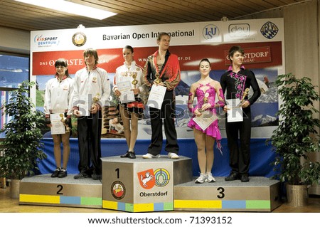 OBERSTDORF, GERMANY - FEBRUARY 13: Winners of junior ice dance competition take the podium during the medal ceremony at Bavarian Open on February 13, 2011 in Oberstdorf, Germany