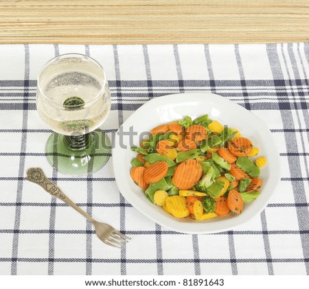 Glass of white wine and vegetable mix on table