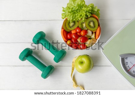 Diet Health food and lifestyle health concept. Sport exercise equipment workout with green apple and measuring tap, fresh salad for fitness style. Healthy Lifestyle Concept 商業照片 © 