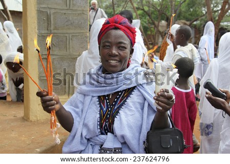 TURMI, ETHIOPIA - NOVEMBER 22, 2011: The woman prays with the burning candles in hands during celebration in orthodox church. November 22, 2011 in Turmi, Ethiopia.