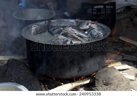 The fish market at Awassa lake, Ethiopia. Preparation of the fish-soup in cauldron.
