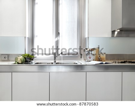 detail of steel sink under the window in a modern white kitchen
