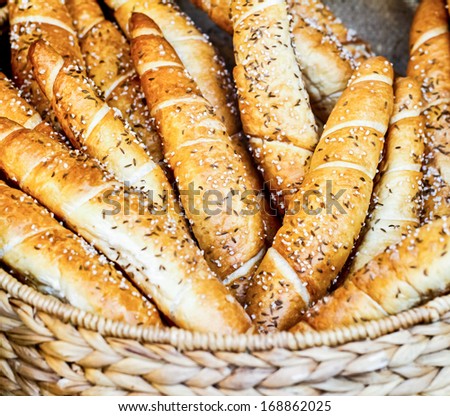 Many loaves of long bread with seeds in wicker basket.