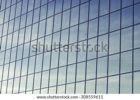 dirty glass windows of an office building, reflection of sky