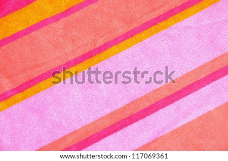 Pretty pink and striped beach towel useful as a background texture