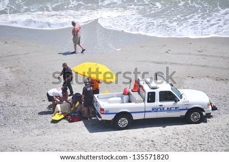 MYRTLE BEACH, SOUTH CAROLINA - APRIL 18 - Paramedics, Beach Police, Lifeguard work together to save unidentified drowning victim at Myrtle Beach on the 18th of April 2013