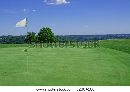 Golf green with flag blowing in wind room for copy space