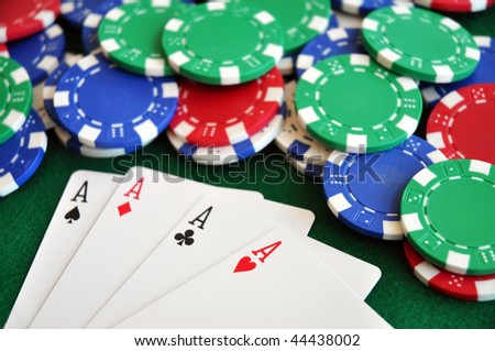 four aces fanned out with colorful poker chips