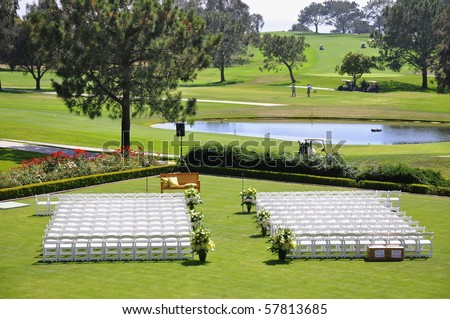 Outdoor wedding reception venue set up with white chairs and golf course view